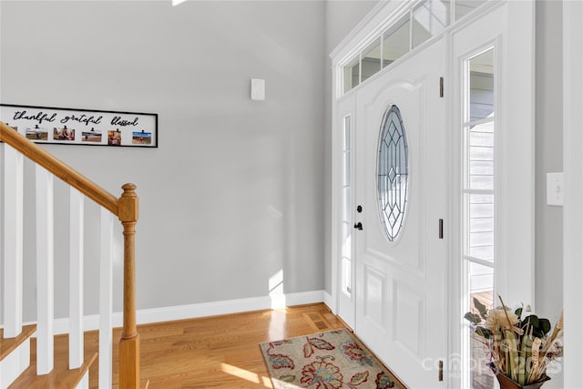 entryway featuring stairway, baseboards, and light wood-type flooring