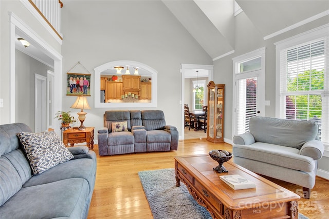living area with plenty of natural light, light wood-style flooring, and high vaulted ceiling
