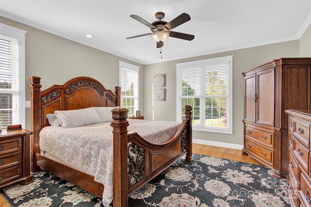 bedroom with a ceiling fan, baseboards, light wood-style floors, and ornamental molding
