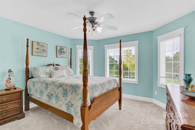 bedroom with ceiling fan, baseboards, and light colored carpet