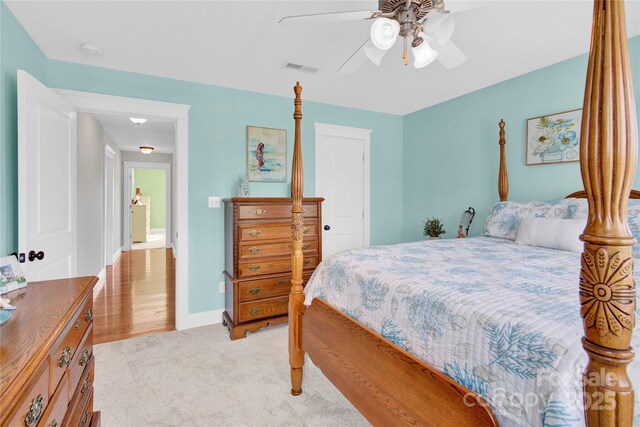 bedroom featuring light colored carpet, ceiling fan, baseboards, and visible vents