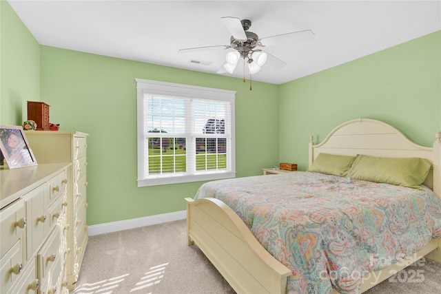 bedroom with visible vents, a ceiling fan, baseboards, and light colored carpet
