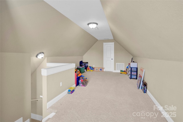 rec room featuring lofted ceiling, baseboards, visible vents, and carpet flooring