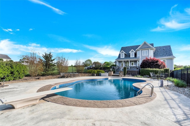 view of pool featuring a fenced in pool, a patio, fence, and a diving board
