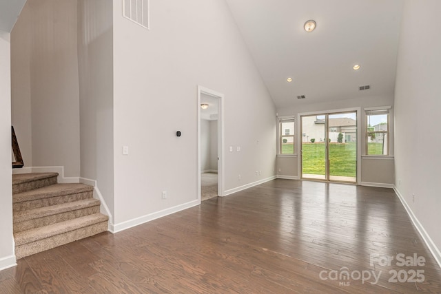 5684 Garrow Glen Rd Unit 96, Charlotte, NC 28278 - unfurnished living room featuring dark wood finished floors, stairway, baseboards, visible vents, and high vaulted ceiling