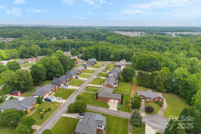 bird's eye view with a wooded view and a residential view