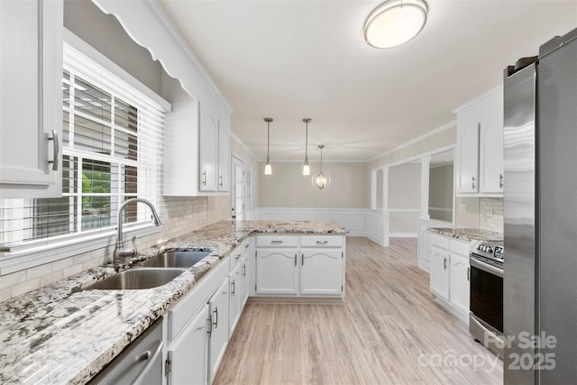 kitchen featuring white cabinetry, stainless steel appliances, a peninsula, and a sink