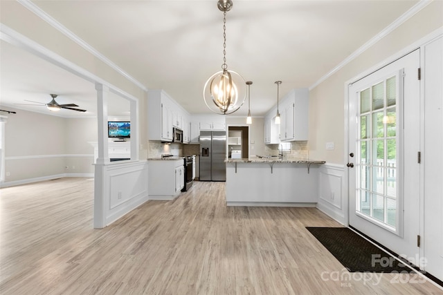 kitchen with a peninsula, tasteful backsplash, light wood-type flooring, open floor plan, and appliances with stainless steel finishes