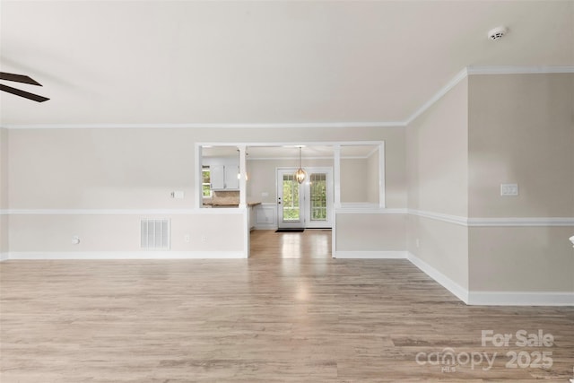 unfurnished room featuring ceiling fan, crown molding, visible vents, and light wood-style floors