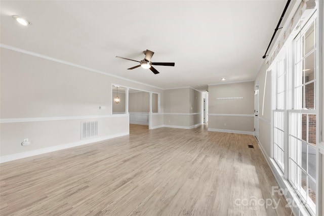 empty room featuring ceiling fan, visible vents, crown molding, baseboards, and light wood finished floors