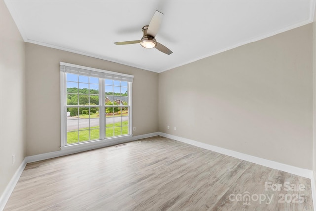 unfurnished room with baseboards, crown molding, and wood finished floors