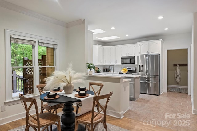 7067 Rocky Falls Rd, Charlotte, NC 28211 - kitchen with stainless steel appliances, white cabinets, a peninsula, light countertops, and crown molding