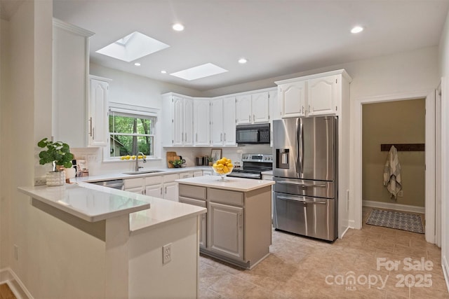 7067 Rocky Falls Rd, Charlotte, NC 28211 - kitchen with appliances with stainless steel finishes, a sink, a skylight, tasteful backsplash, and recessed lighting