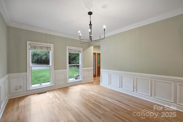 7067 Rocky Falls Rd, Charlotte, NC 28211 - unfurnished dining area with a chandelier, light wood-style flooring, a wainscoted wall, crown molding, and a decorative wall