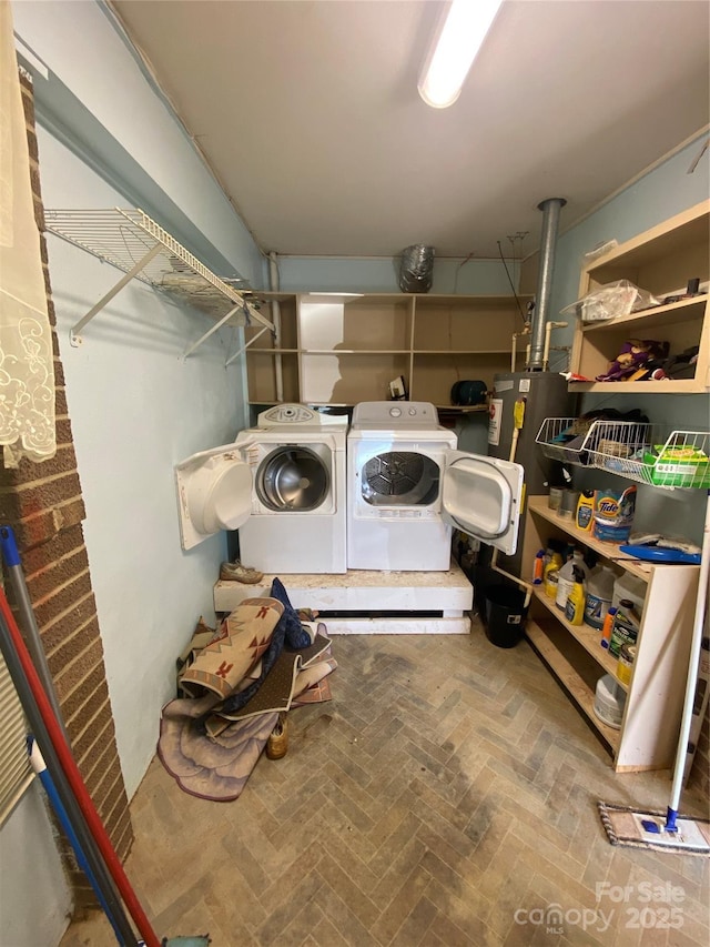 clothes washing area with brick floor, gas water heater, washer and clothes dryer, and laundry area