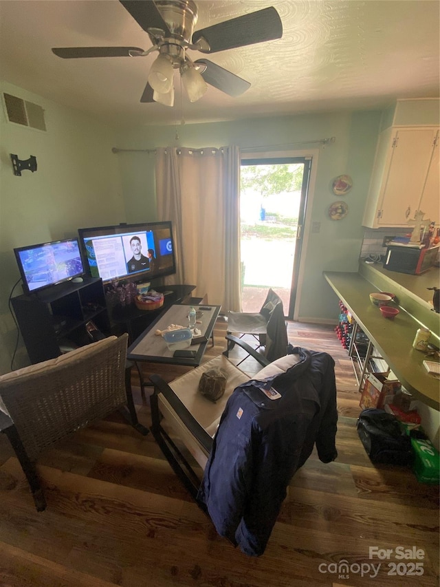 living room featuring wood finished floors, visible vents, and ceiling fan