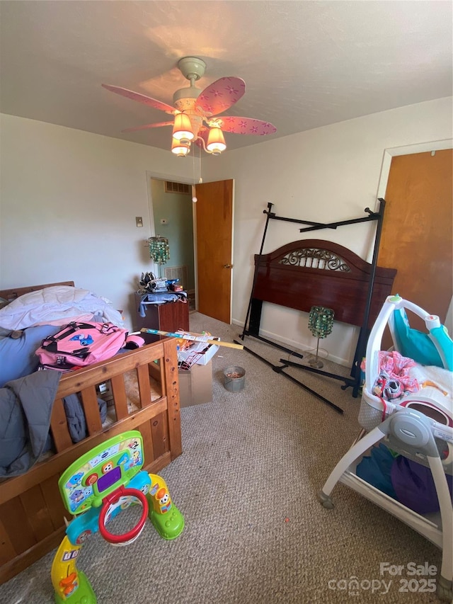 carpeted bedroom with a ceiling fan and visible vents