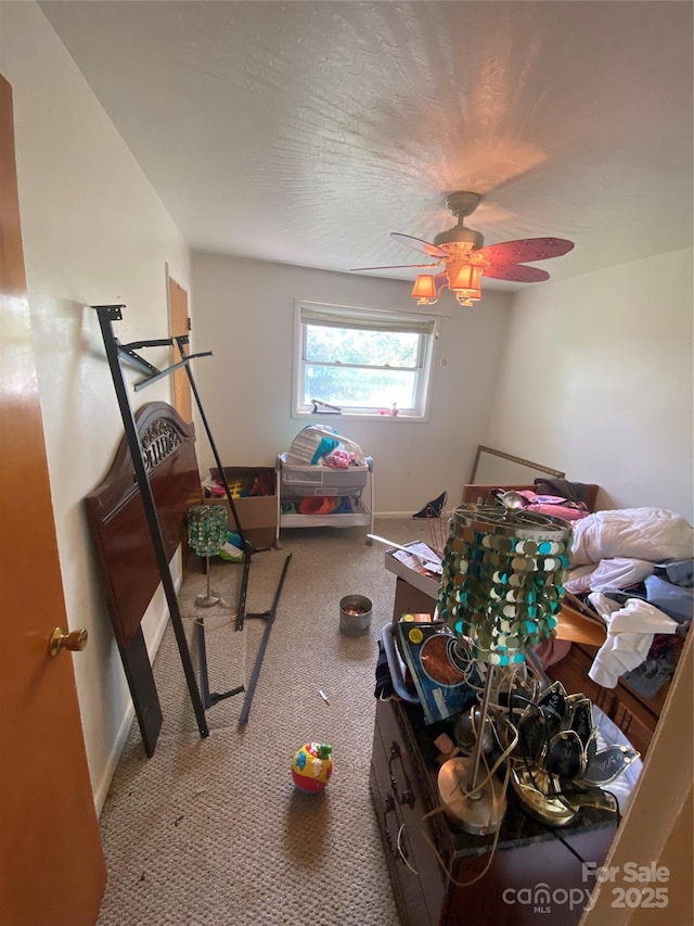 interior space with baseboards, ceiling fan, and carpet