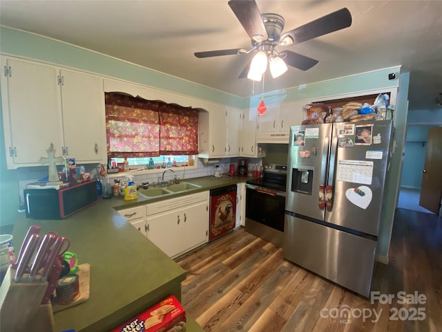 kitchen featuring stainless steel appliances, under cabinet range hood, dark wood-style flooring, a sink, and white cabinetry