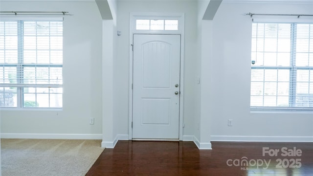 entrance foyer with arched walkways, plenty of natural light, and baseboards