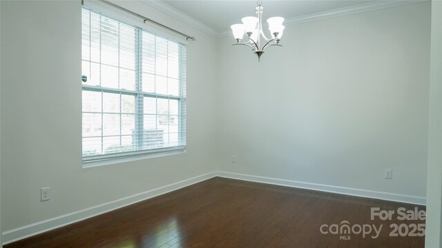 empty room with dark wood-style flooring, a notable chandelier, baseboards, and a wealth of natural light