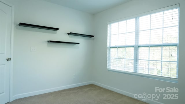 carpeted spare room with baseboards