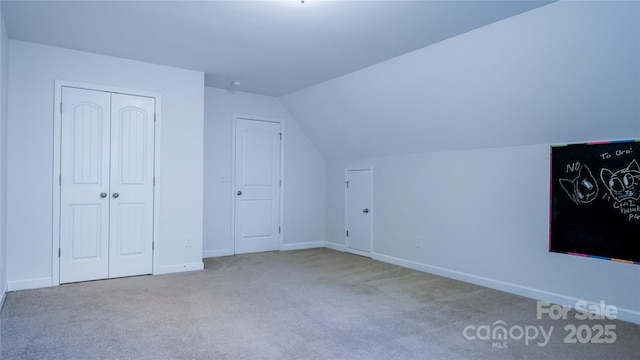 additional living space featuring baseboards, carpet flooring, and vaulted ceiling