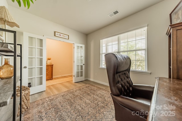 office space with wood finished floors, visible vents, french doors, and baseboards
