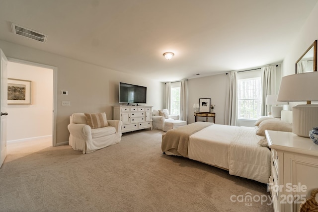 bedroom with visible vents and light carpet
