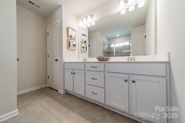 full bathroom with double vanity, visible vents, a stall shower, baseboards, and tile patterned floors