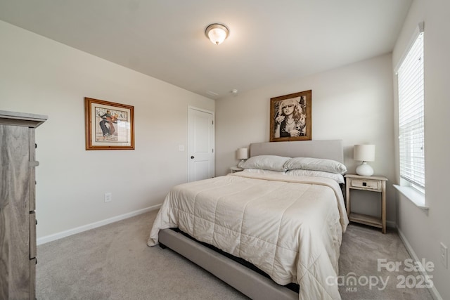 carpeted bedroom featuring baseboards and multiple windows