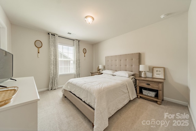 bedroom with baseboards, visible vents, and light colored carpet