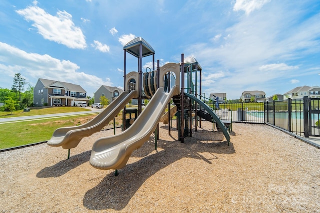 community play area featuring fence and a residential view