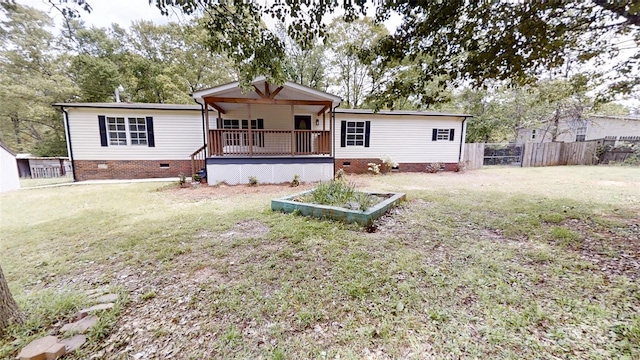 rear view of property with a lawn, fence, and crawl space
