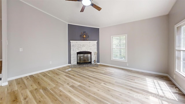 unfurnished living room with a ceiling fan, light wood-style floors, a fireplace, and baseboards