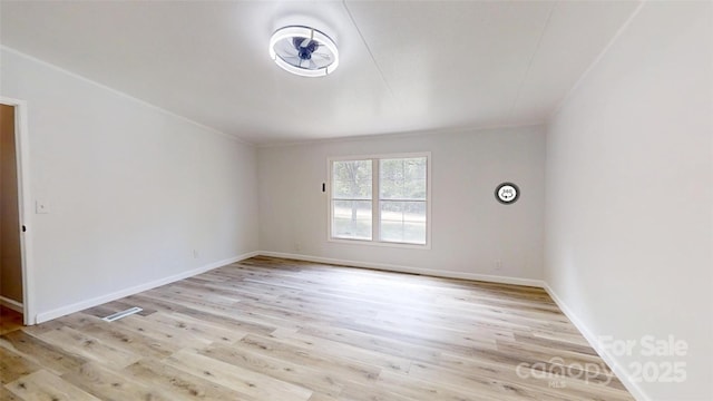 unfurnished room featuring baseboards and light wood-style floors