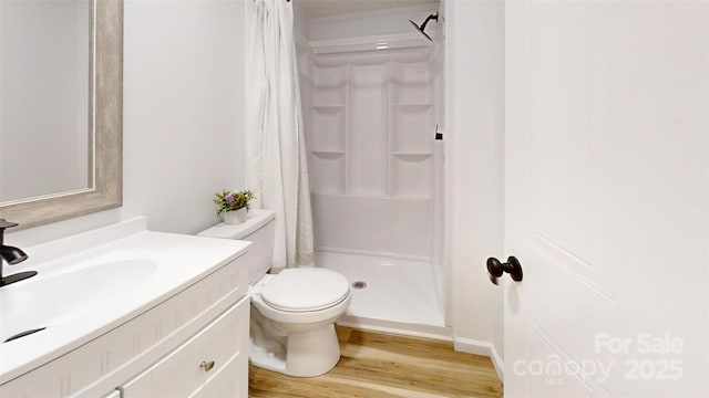 full bath featuring vanity, toilet, a stall shower, and wood finished floors