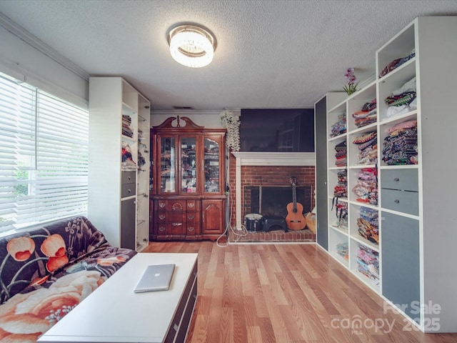 6820 Elm Forest Dr, Charlotte, NC 28212 - living area featuring a brick fireplace, a textured ceiling, crown molding, and wood finished floors