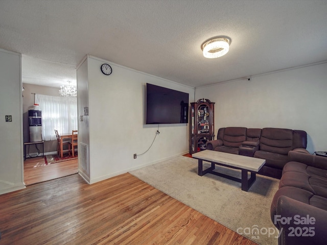 6820 Elm Forest Dr, Charlotte, NC 28212 - living room with baseboards, a chandelier, a textured ceiling, visible vents, and wood finished floors
