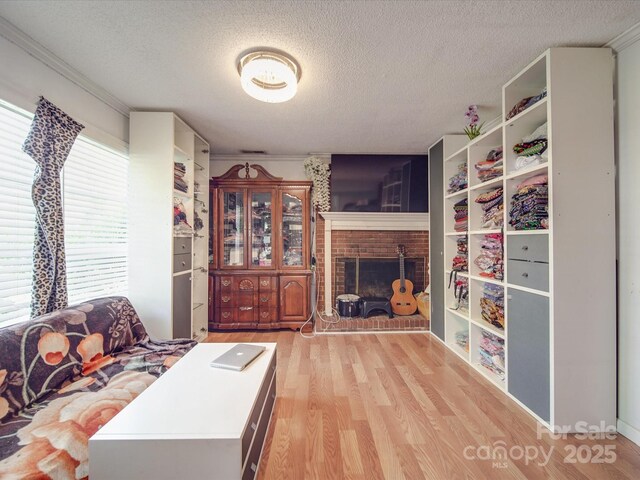 6820 Elm Forest Dr, Charlotte, NC 28212 - living area with a textured ceiling, wood finished floors, ornamental molding, and a brick fireplace