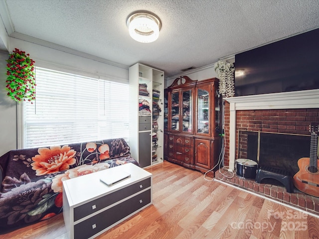 6820 Elm Forest Dr, Charlotte, NC 28212 - living room with visible vents, a fireplace, crown molding, a textured ceiling, and wood finished floors