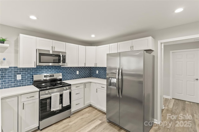 109 W Poplar St, Stanley, NC 28164 - kitchen with stainless steel appliances, light countertops, white cabinetry, light wood-style floors, and recessed lighting