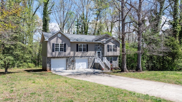bi-level home with a front lawn, stone siding, an attached garage, driveway, and stairway