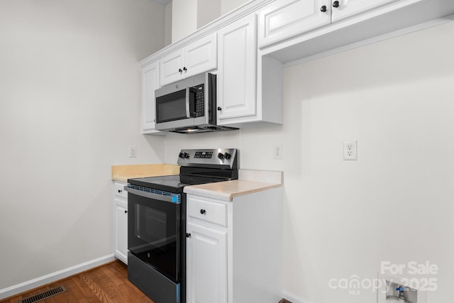 kitchen with visible vents, light countertops, baseboards, dark wood-style floors, and stainless steel appliances