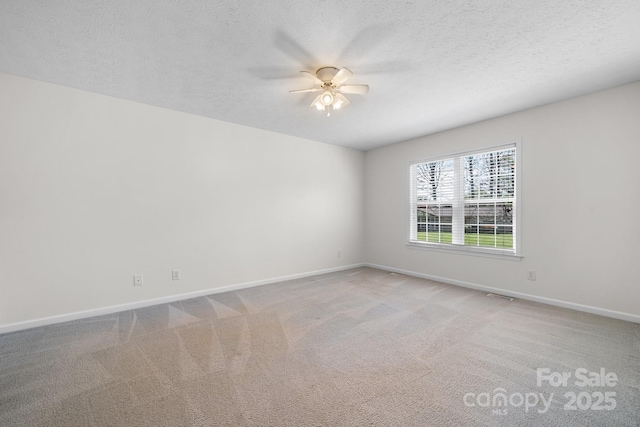 unfurnished room featuring baseboards, ceiling fan, light colored carpet, and visible vents