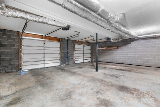 garage with concrete block wall and a garage door opener