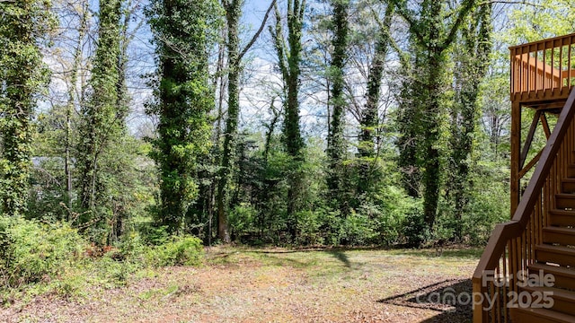 view of yard with a wooden deck and stairs
