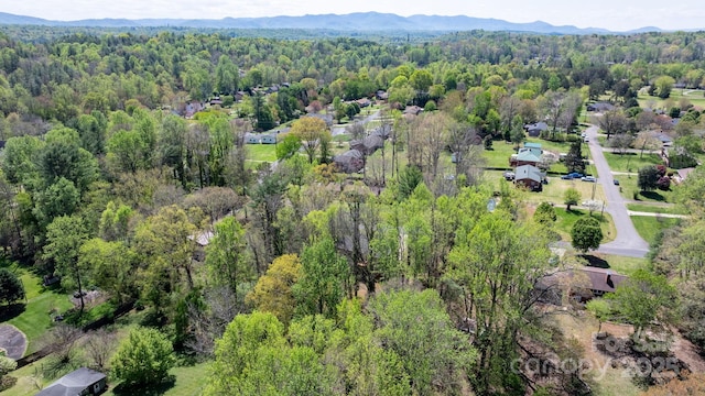 drone / aerial view featuring a forest view and a mountain view
