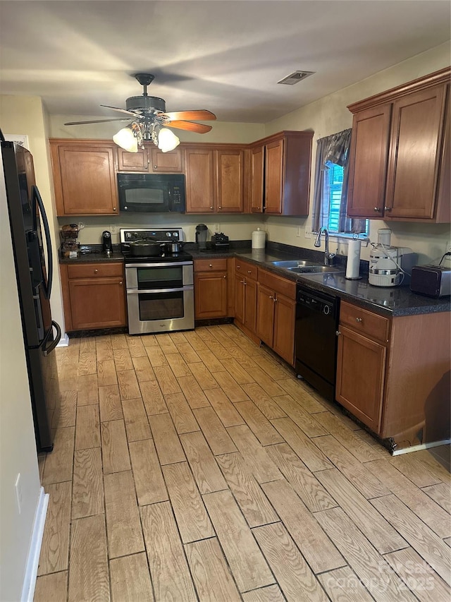 kitchen featuring a sink, light wood-style flooring, black appliances, and ceiling fan