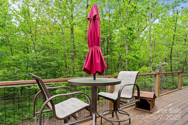 wooden terrace with a wooded view